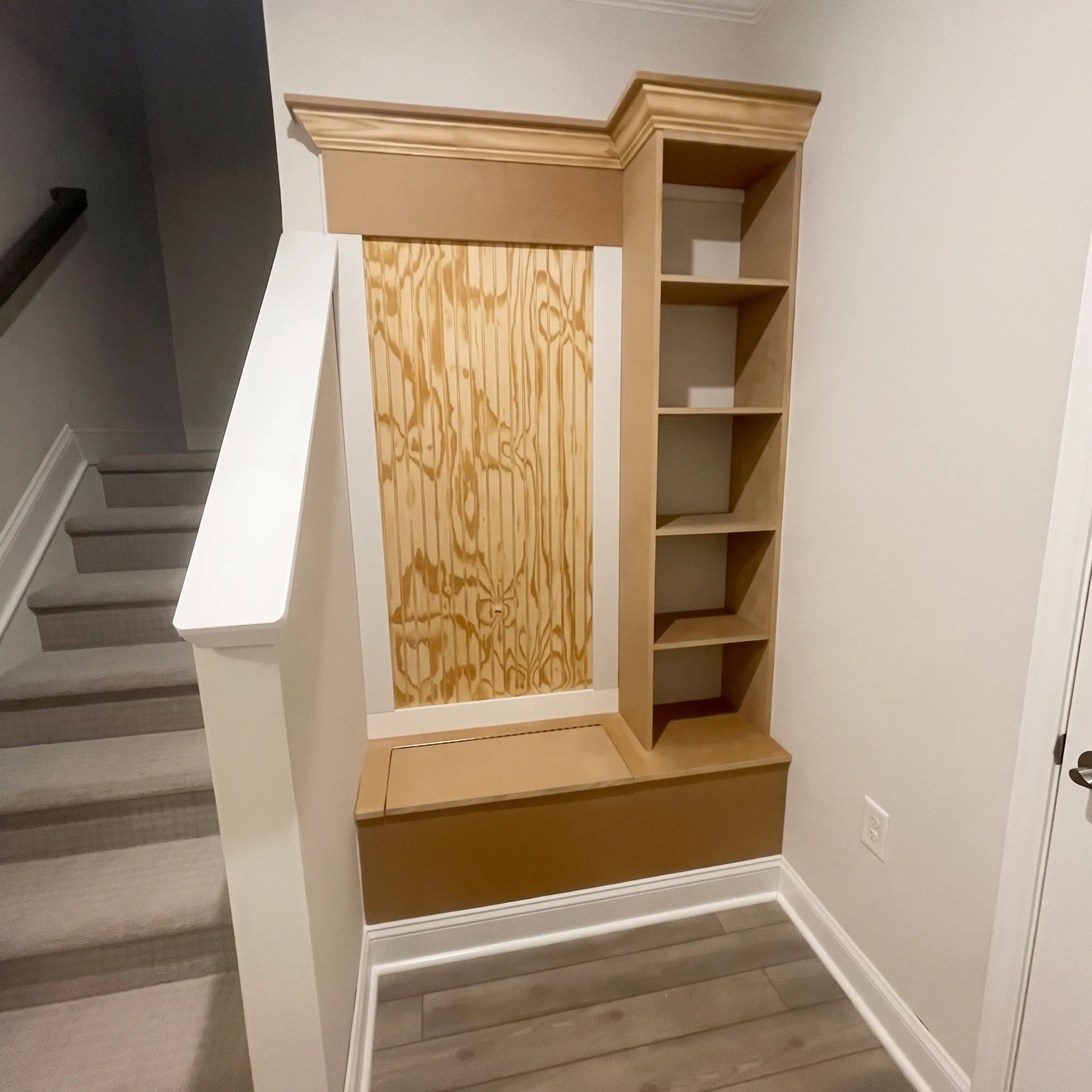 Custom built-in bench, cubbies, and shelving drop zone beside a staircase, built by JND Home Solutions