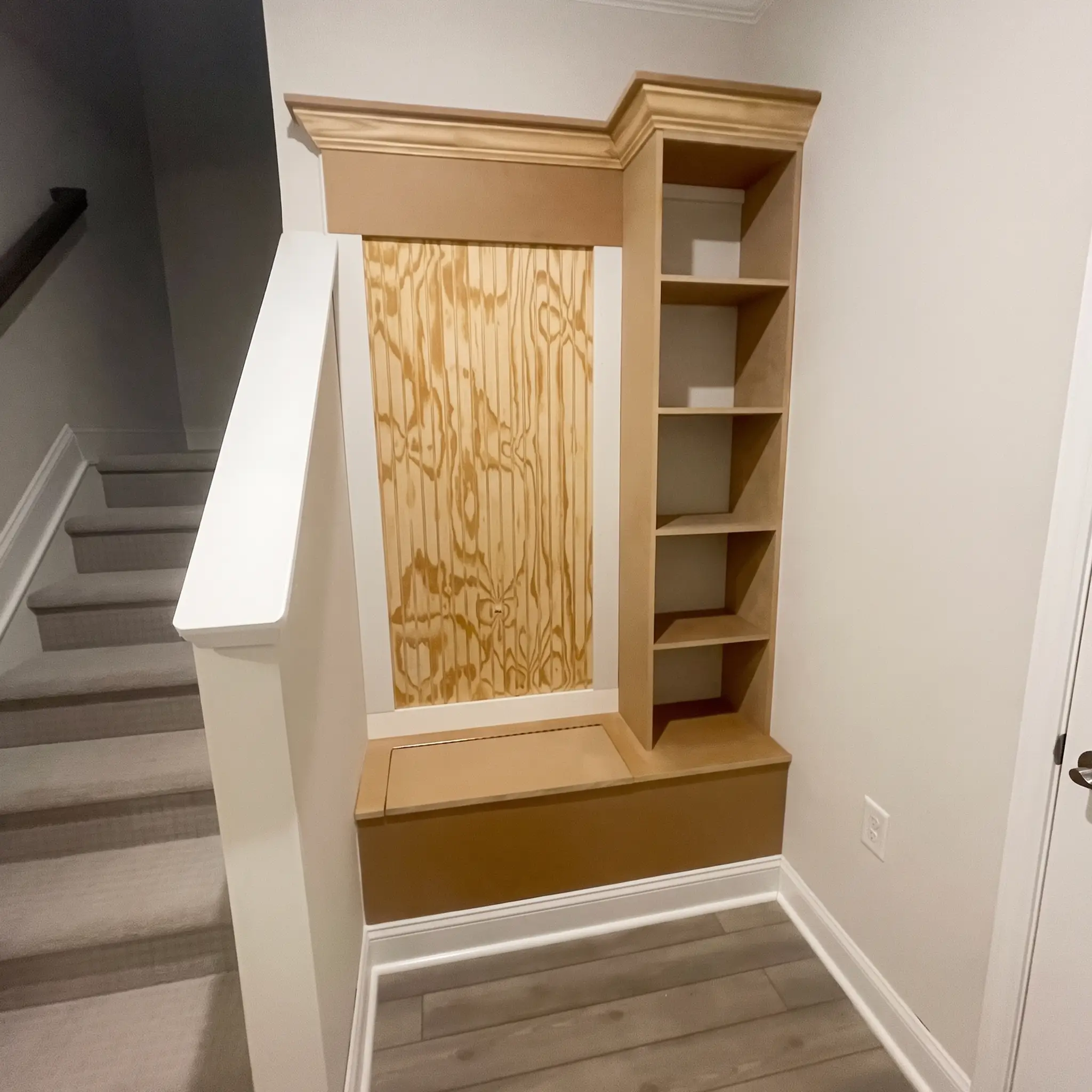 Custom built-in bench and shelving beside a staircase