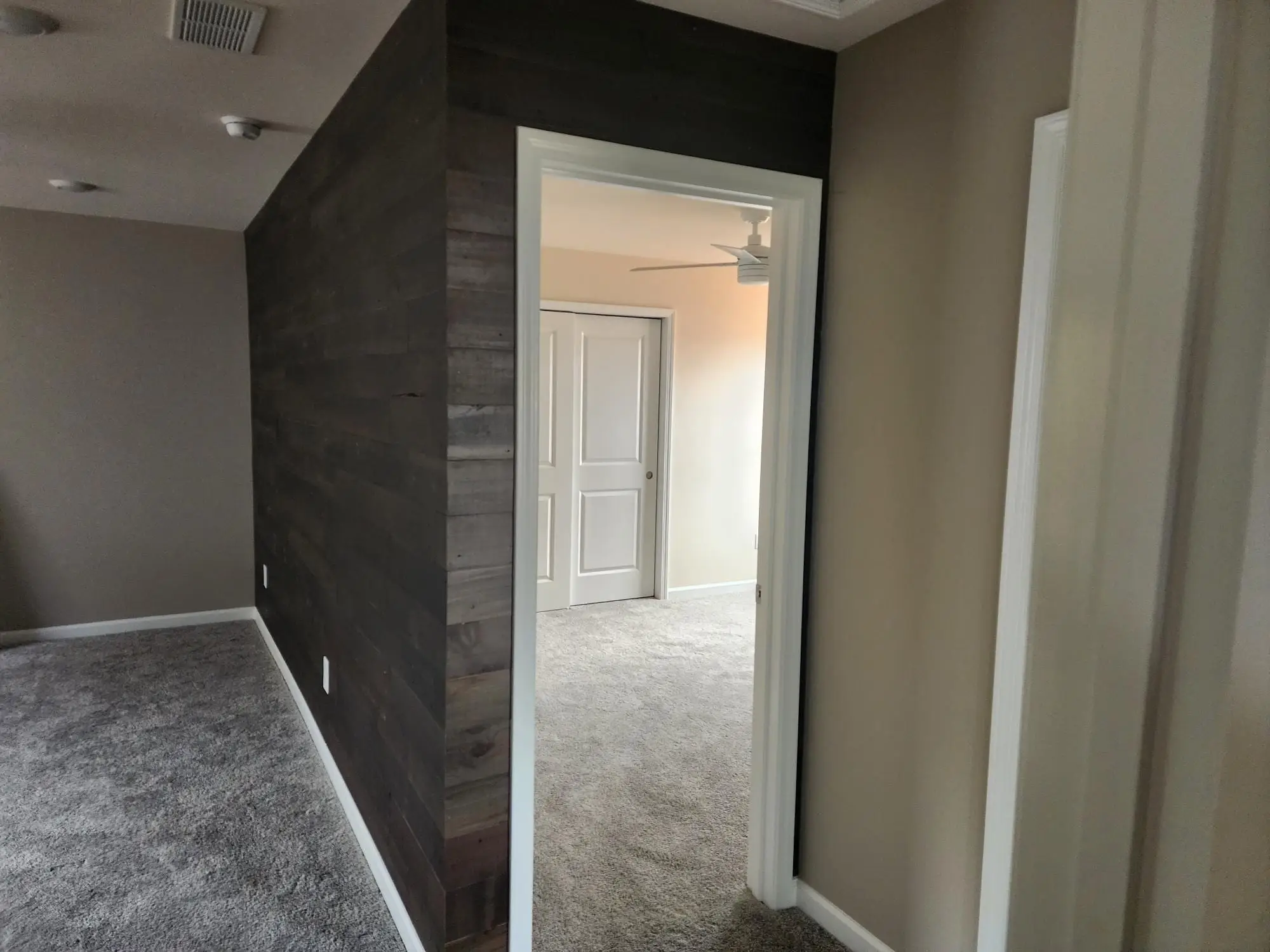 Finished dark plank feature wall running down a hallway