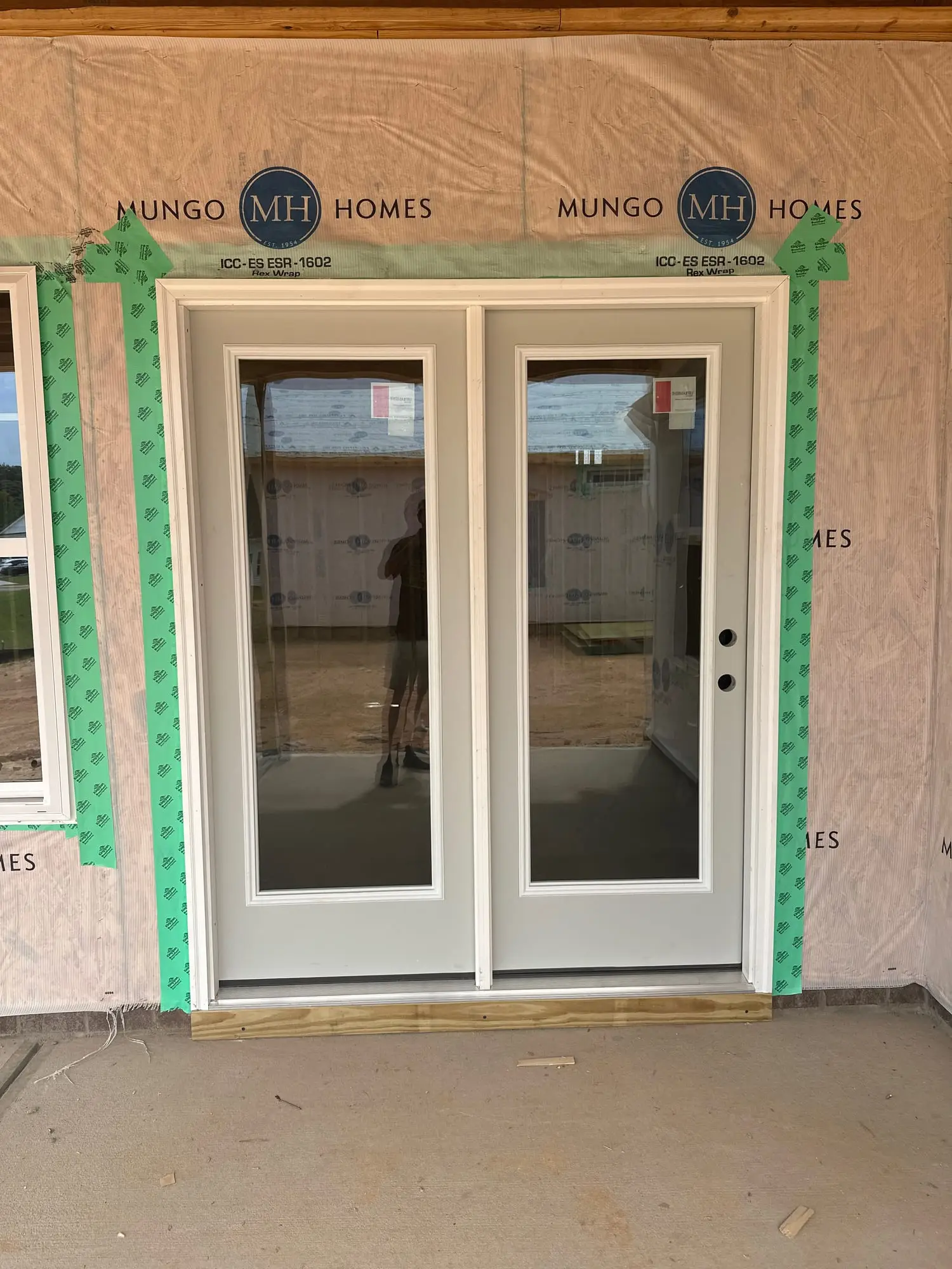 Double French patio doors set into the back wall of a home under construction