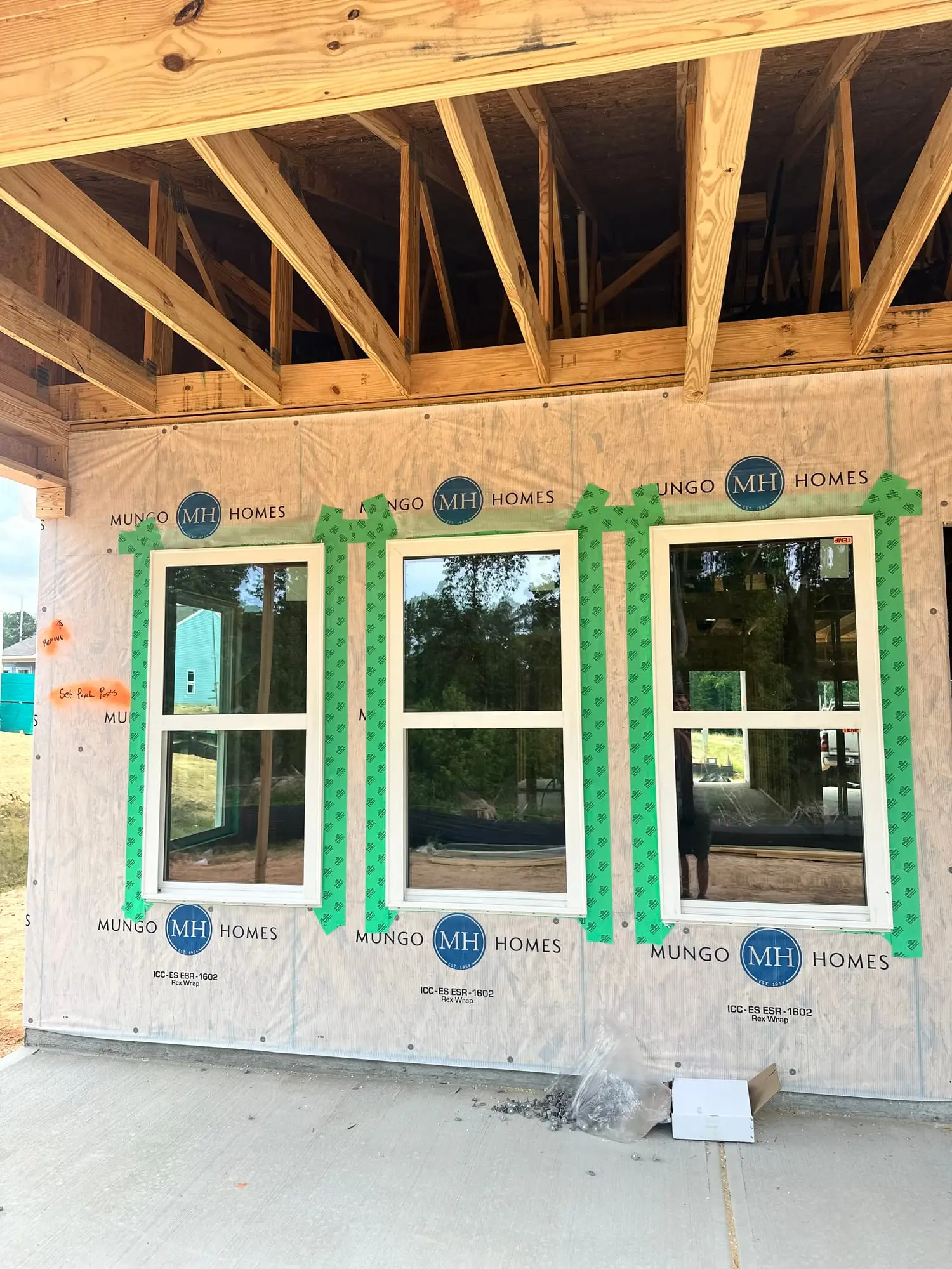 Three new windows installed in an exterior wall on a home under construction