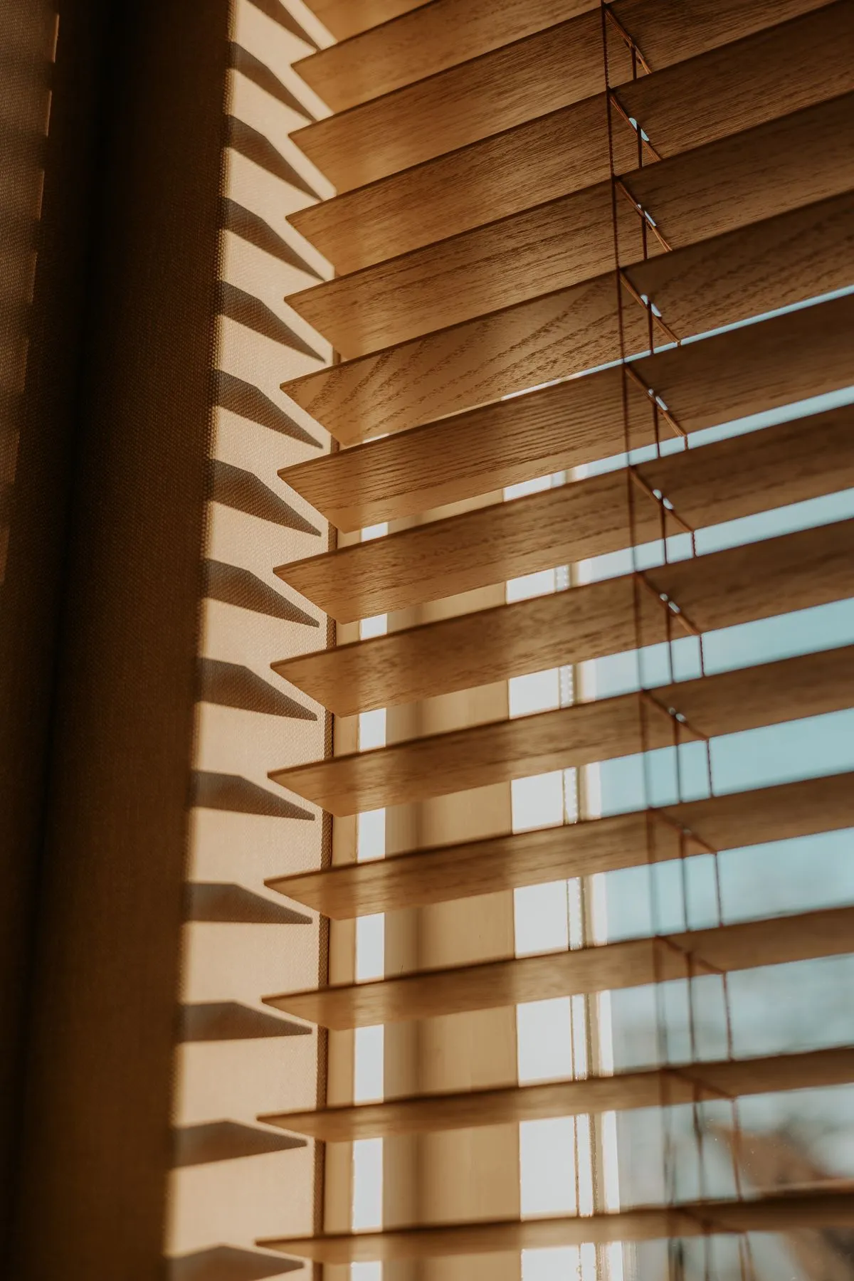 Warm wood window blinds letting in soft daylight